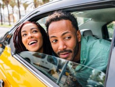 Happy couple traveling from Saundersfoot to Tenby area in a Z Car taxi cab. Convenient and comfortable transportation between Saundersfoot and Tenby provided by Z Car taxis.